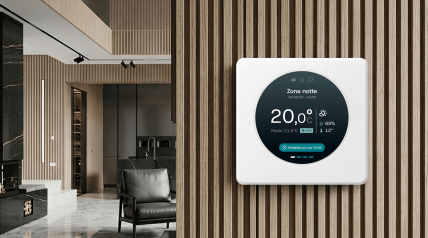 Kerberos smart thermostat mounted on a wall in a home environment, with a circular display showing temperature, humidity, and system status.
