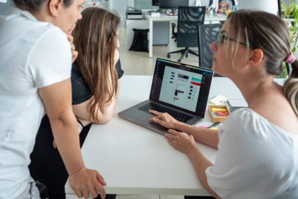 Three Tangiblers stare at a laptop screen. A Design Ops file is displayed.