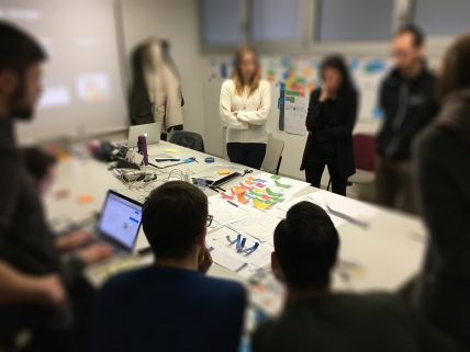 Foto del team durante un meeting, attorno ad un tavolo con post it e schizzi di carta