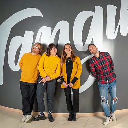 Valentina standing with her back to the wall next to some colleagues