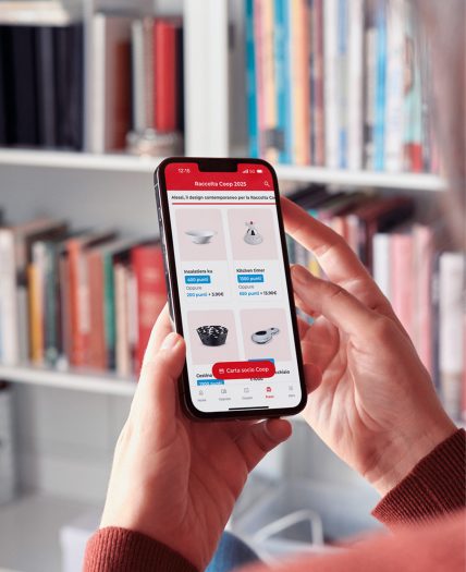 Persona tiene in mano uno smartphone con l’app Coop aperta sulla raccolta punti.