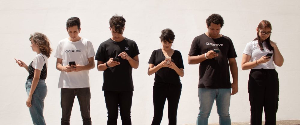 immagine di tre ragazze e tre ragazzi che usano ognuno il proprio smartphone