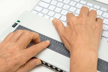 Una persona non vedente legge su un display braille dallo schermo del computer